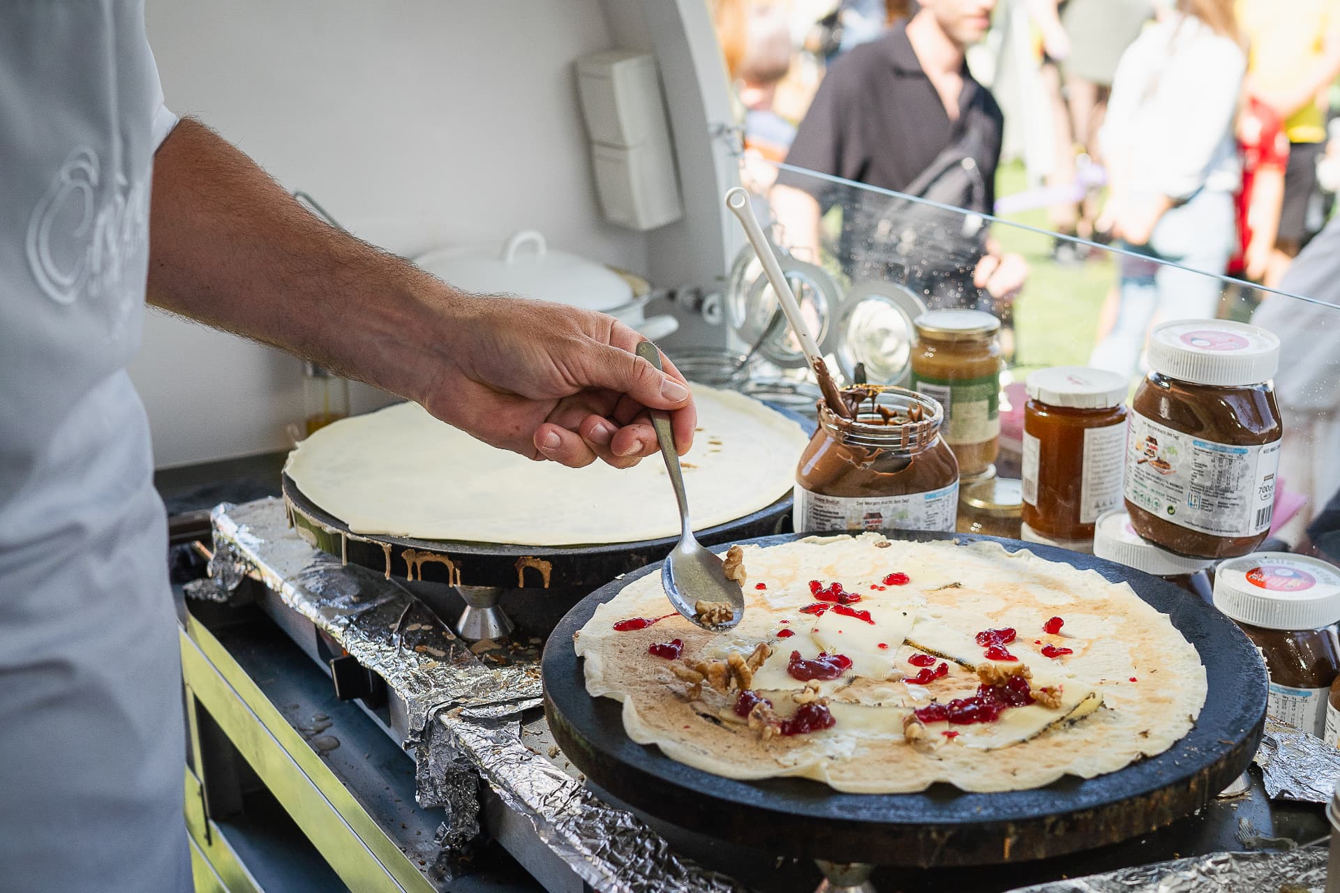 Herzhafte Galette wird bei einem Sommerfest frisch belegt