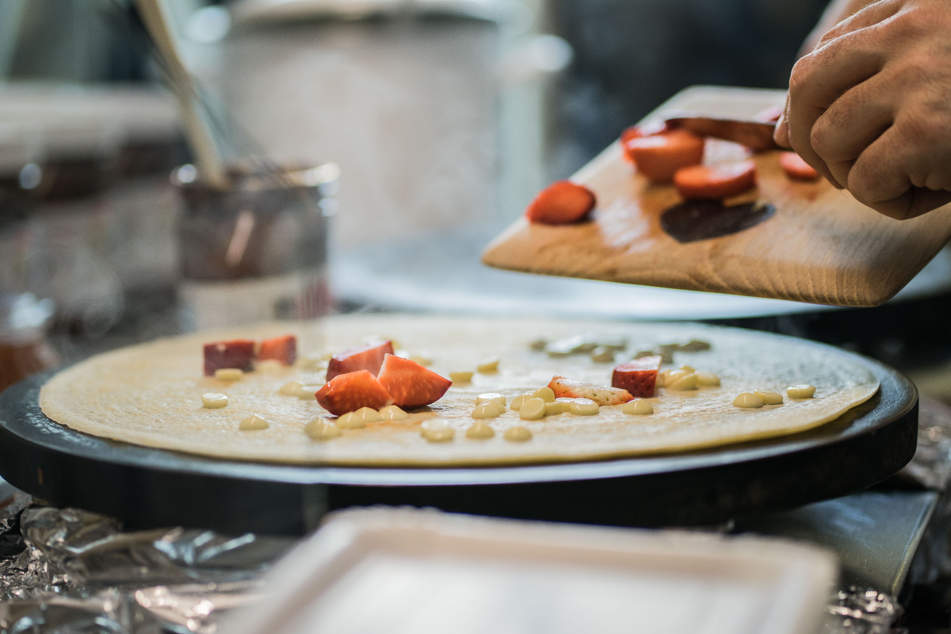 Crêpe mit frischen Erdbeeren und weißer Schokolade auf der Crêpe-Platte