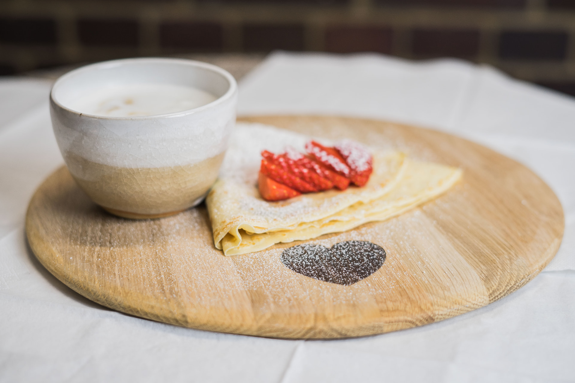 Frisch zubereiteter Crêpe mit Erdbeeren und Bio-Cappuccino