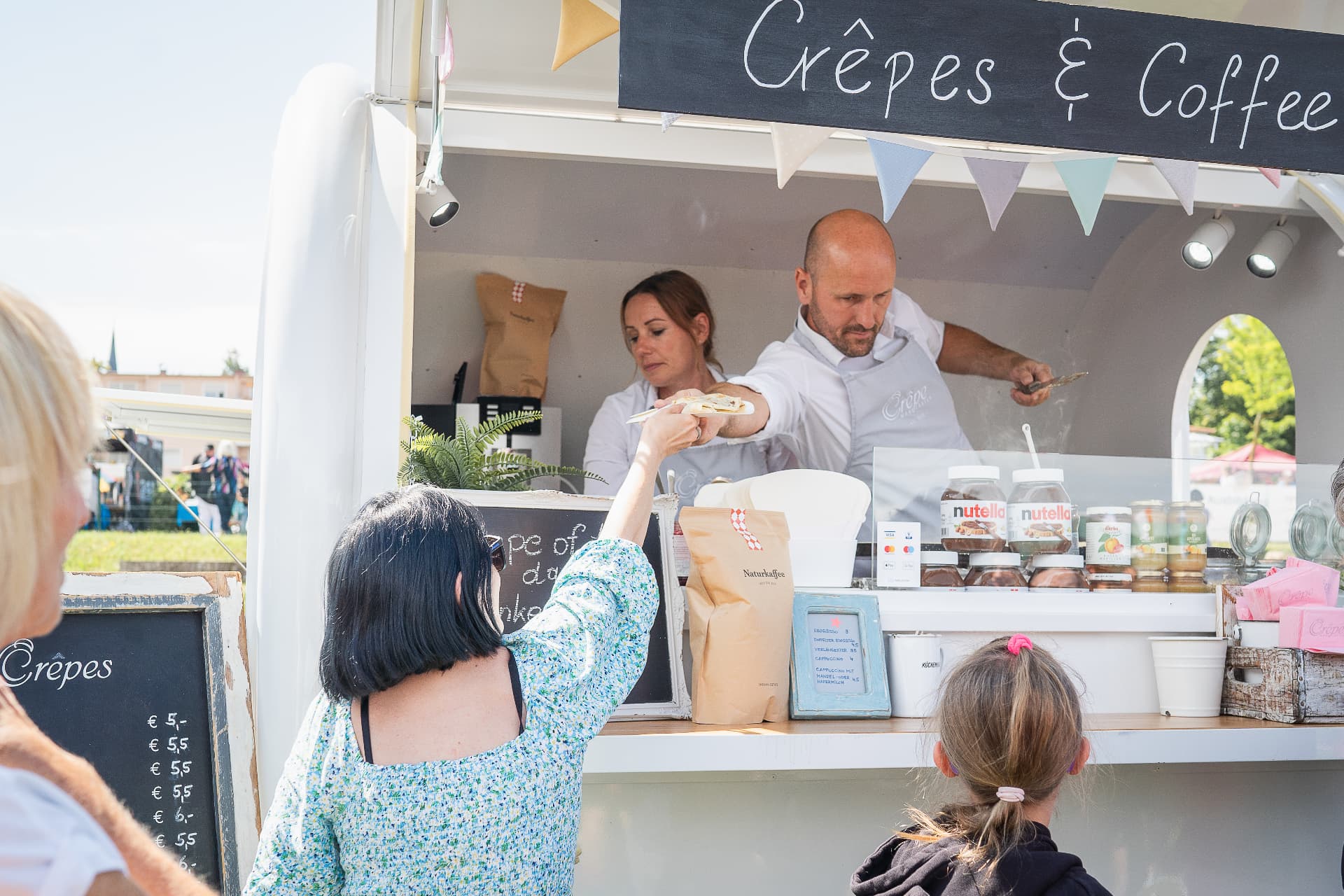 Gäste holen sich frische Crêpes am Trailer bei einer privaten Feier